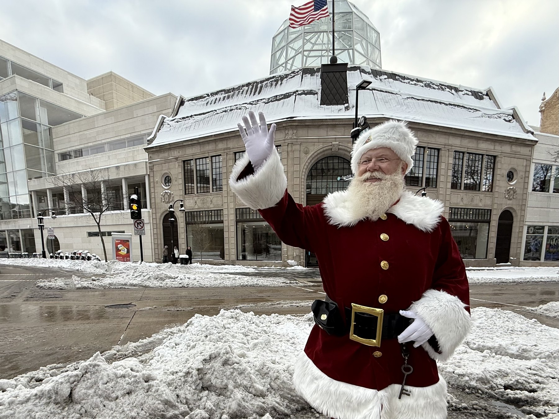 Santa waving outside on a snowy downtown Madison street