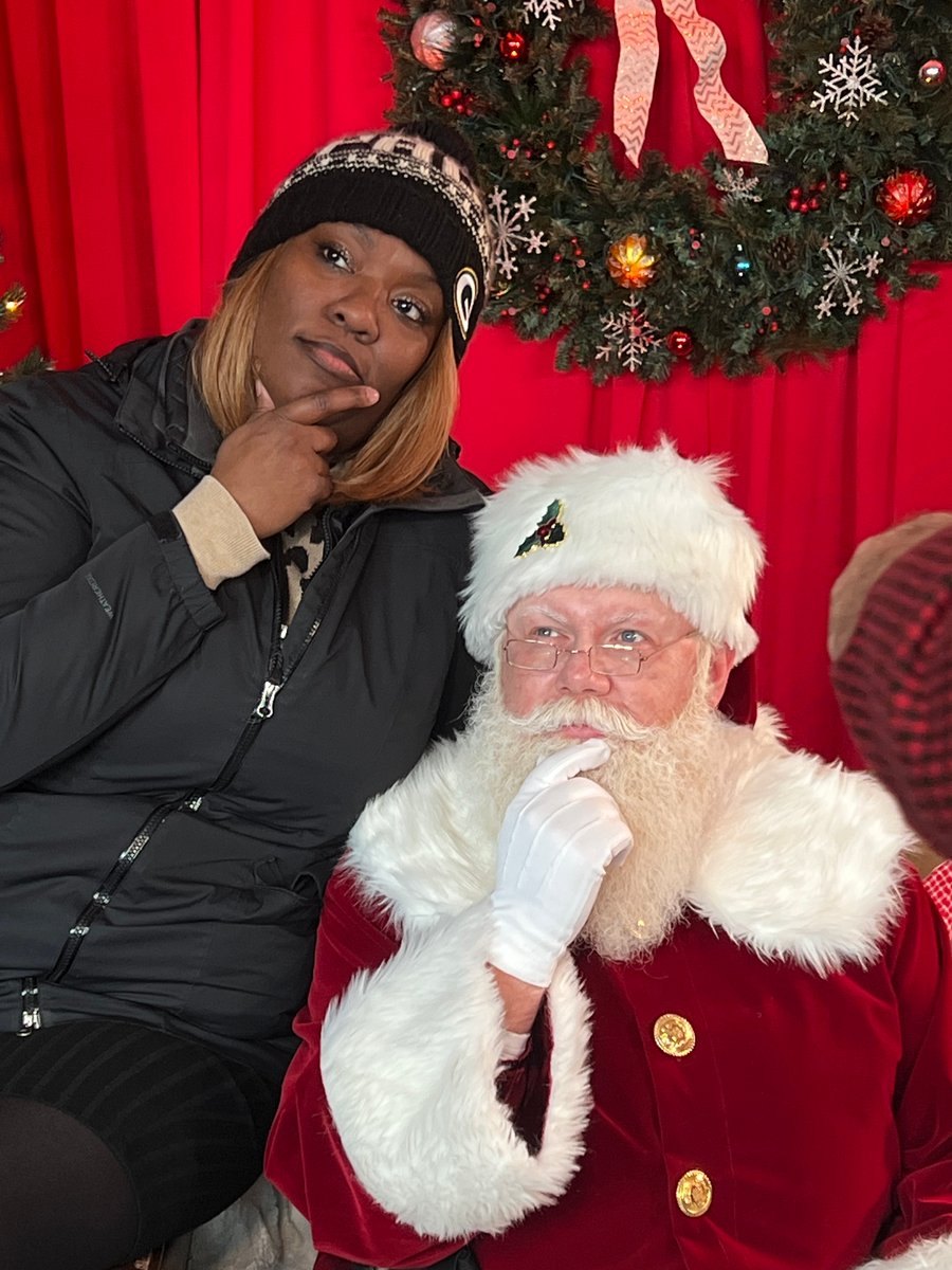 A visitor and Santa making matching thoughtful poses